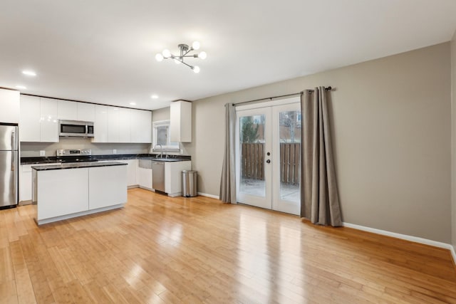 kitchen featuring white cabinets, stainless steel appliances, french doors, and a kitchen island