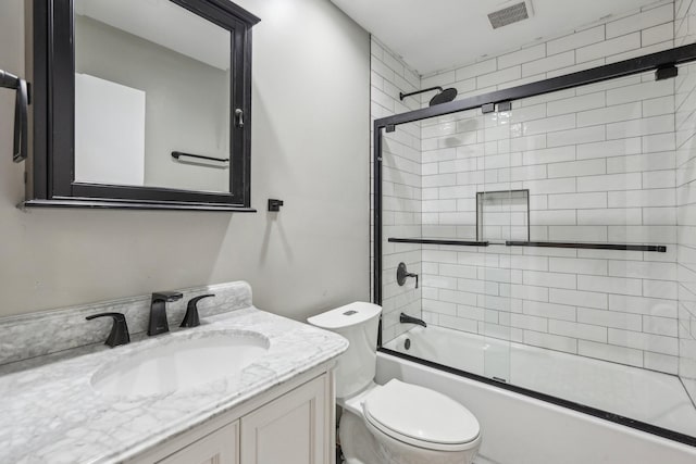 full bathroom featuring toilet, enclosed tub / shower combo, and vanity