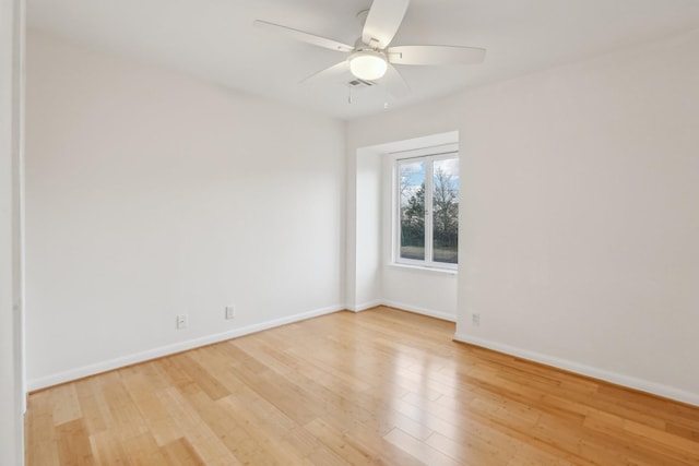 empty room with ceiling fan and light hardwood / wood-style flooring