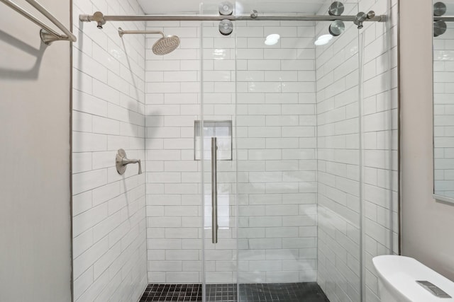 bathroom featuring an enclosed shower and toilet