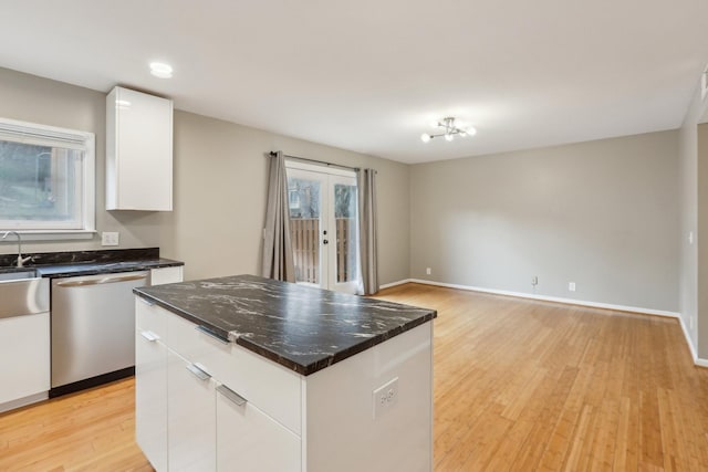 kitchen featuring dishwasher, a kitchen island, white cabinetry, french doors, and light hardwood / wood-style floors