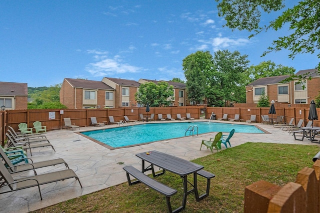 view of swimming pool featuring a yard and a patio