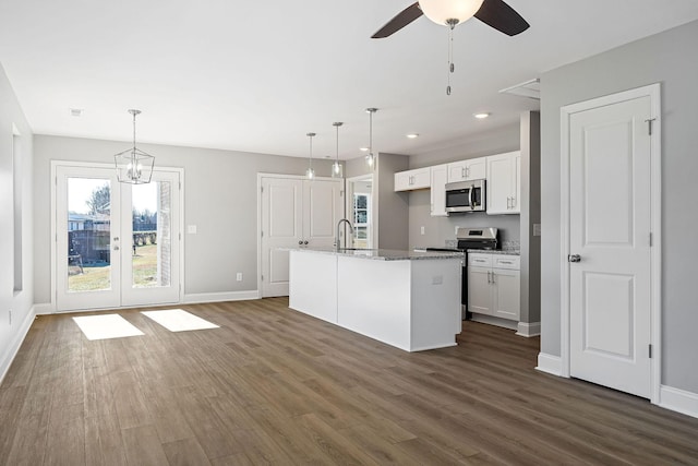 kitchen featuring pendant lighting, white cabinetry, a kitchen island with sink, and appliances with stainless steel finishes