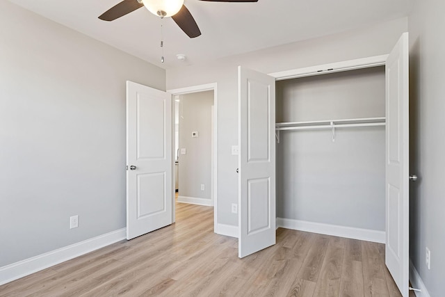 unfurnished bedroom featuring ceiling fan, a closet, and light wood-type flooring