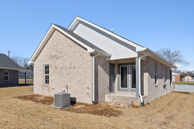 view of property exterior featuring french doors and central air condition unit