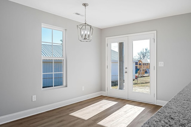 doorway to outside with hardwood / wood-style floors, a notable chandelier, and french doors