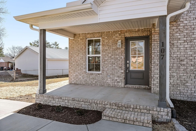 view of exterior entry featuring covered porch