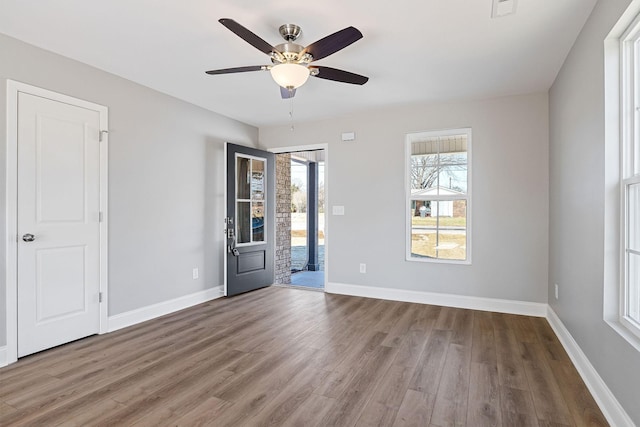 unfurnished room featuring ceiling fan, a healthy amount of sunlight, and hardwood / wood-style flooring