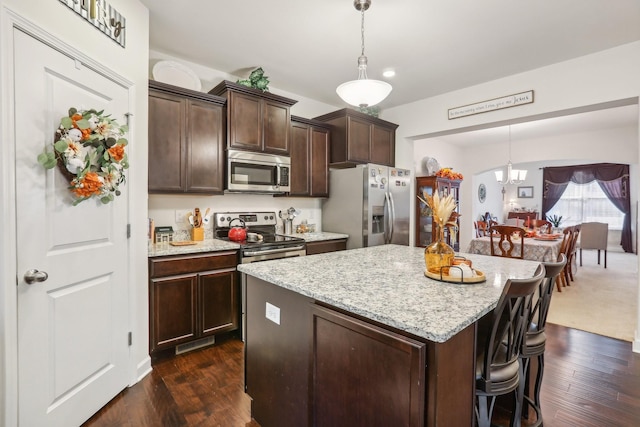 kitchen featuring decorative light fixtures, dark hardwood / wood-style flooring, stainless steel appliances, and dark brown cabinets