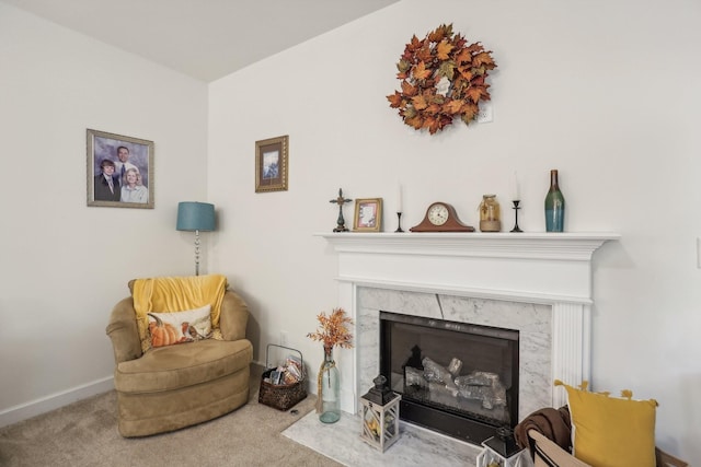 sitting room featuring carpet flooring and a high end fireplace