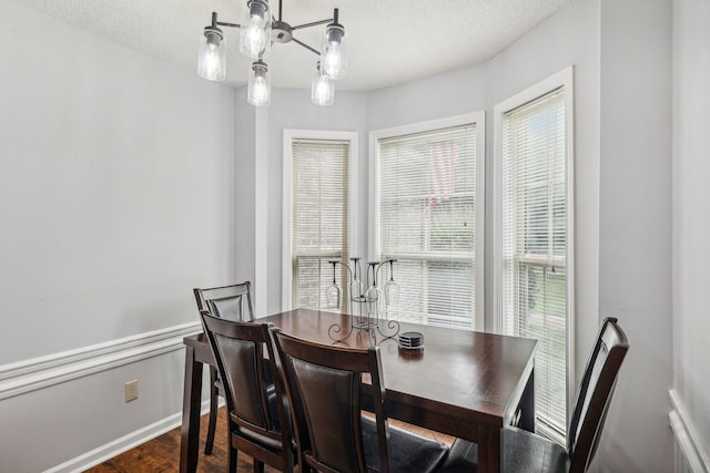 dining area with a textured ceiling and dark wood-type flooring