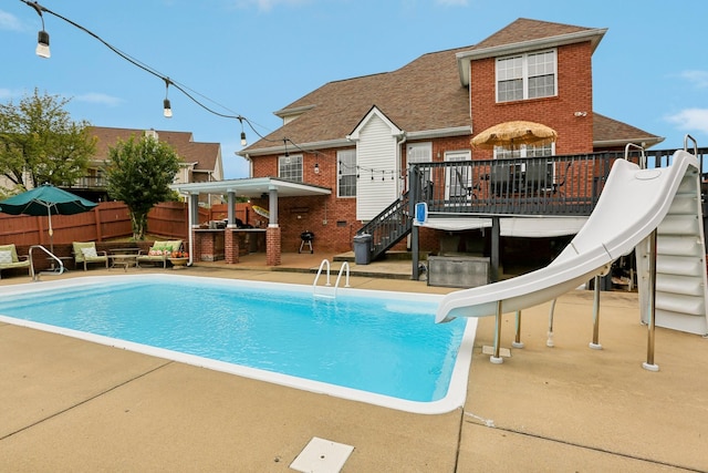 view of swimming pool with a patio area and a water slide