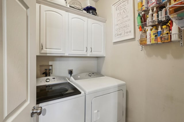 clothes washing area featuring washing machine and dryer and cabinets