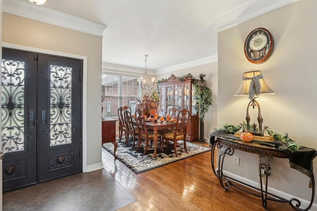 entrance foyer with a notable chandelier, french doors, crown molding, and hardwood / wood-style flooring