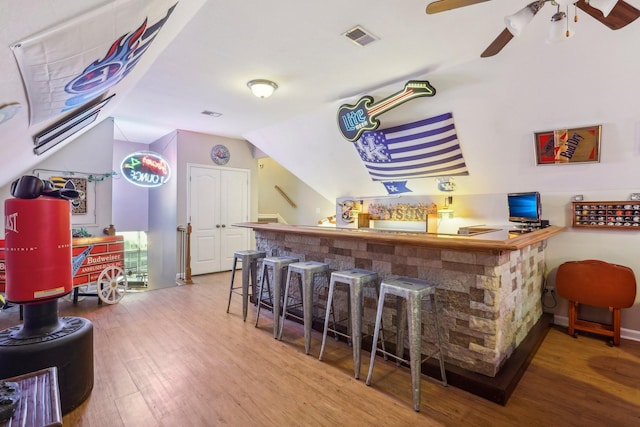 bar featuring lofted ceiling, hardwood / wood-style flooring, and ceiling fan