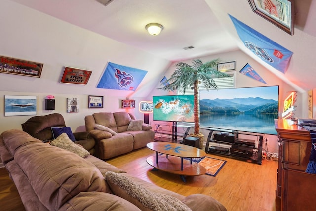 living room featuring lofted ceiling and hardwood / wood-style flooring