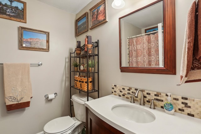 bathroom featuring toilet, vanity, and backsplash