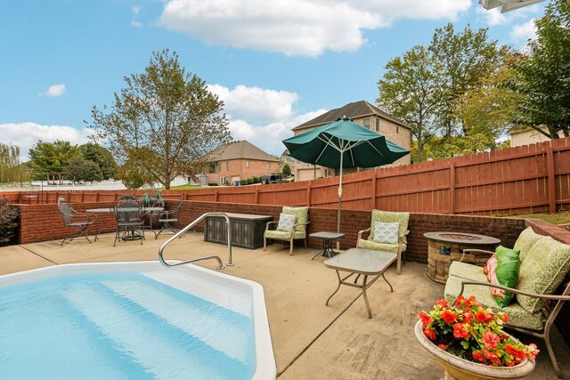 view of pool featuring an outdoor fire pit and a patio