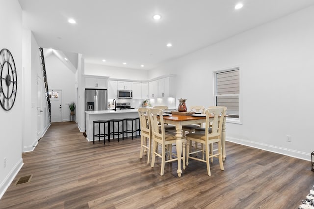 dining area featuring sink and dark wood-type flooring