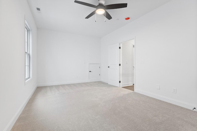 carpeted spare room featuring ceiling fan and a wealth of natural light