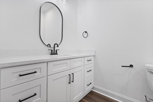 bathroom with hardwood / wood-style floors, vanity, and toilet