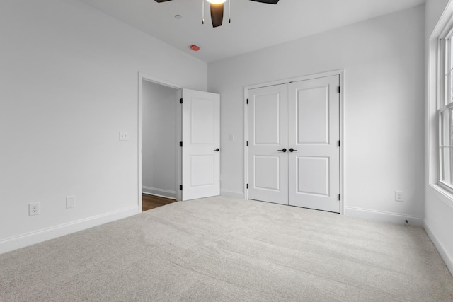 unfurnished bedroom with carpet flooring, ceiling fan, and a closet