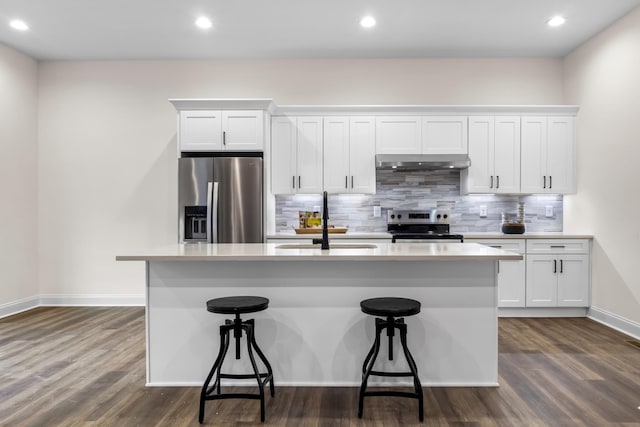 kitchen featuring appliances with stainless steel finishes, a breakfast bar, sink, white cabinets, and an island with sink