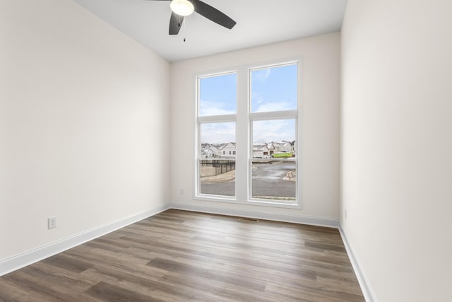 unfurnished room with dark hardwood / wood-style floors and ceiling fan