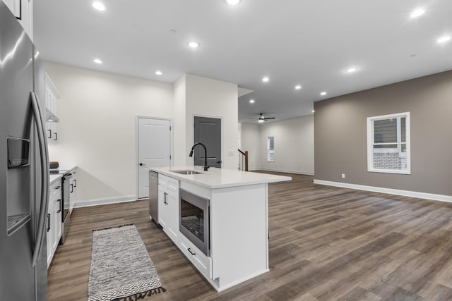 kitchen featuring a kitchen island with sink, sink, ceiling fan, white cabinetry, and stainless steel appliances