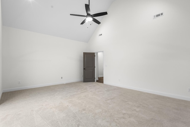 carpeted empty room with high vaulted ceiling and ceiling fan