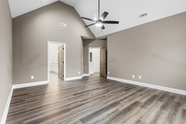 unfurnished bedroom featuring connected bathroom, ceiling fan, high vaulted ceiling, and dark wood-type flooring