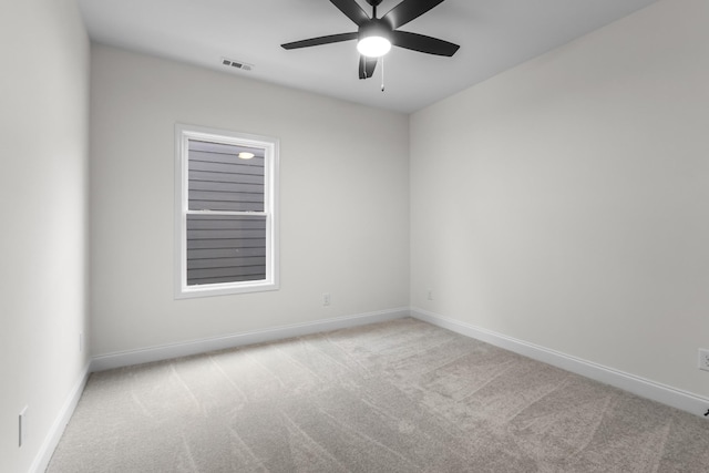 empty room featuring ceiling fan and light colored carpet