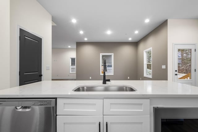 kitchen with white cabinetry, light stone countertops, dishwasher, beverage cooler, and sink