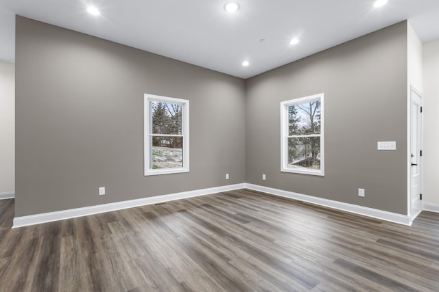 empty room with dark hardwood / wood-style floors and a wealth of natural light