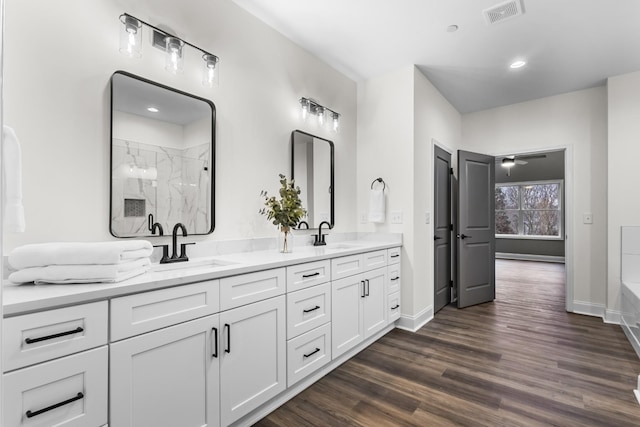 bathroom featuring ceiling fan, hardwood / wood-style floors, vanity, and walk in shower