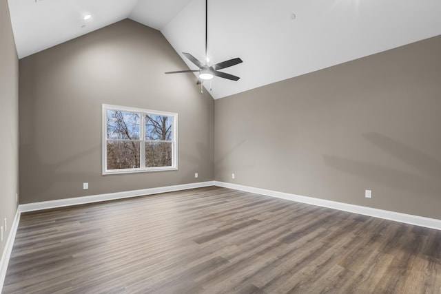 empty room featuring ceiling fan, high vaulted ceiling, and dark wood-type flooring