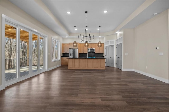 kitchen featuring dark countertops, appliances with stainless steel finishes, dark wood-type flooring, light brown cabinets, and baseboards