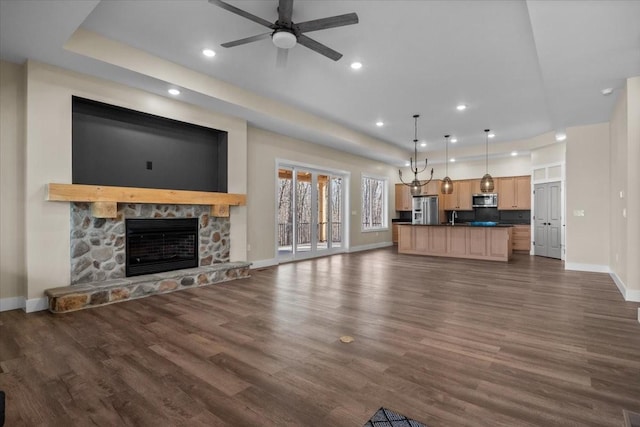 unfurnished living room featuring baseboards, a ceiling fan, dark wood-style flooring, a fireplace, and recessed lighting