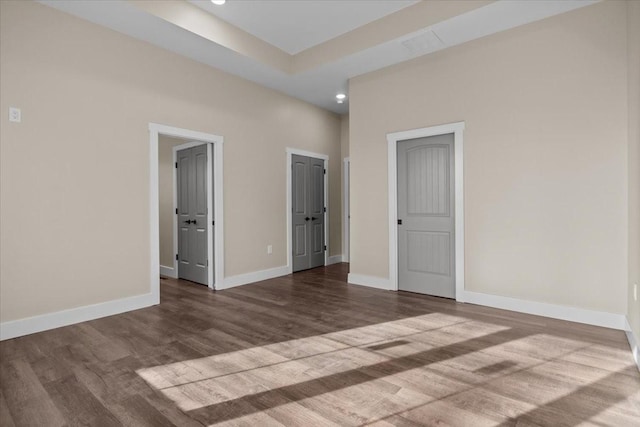 unfurnished bedroom featuring wood finished floors and baseboards