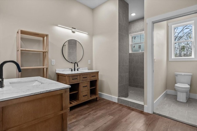 bathroom featuring a walk in shower, a sink, and wood finished floors