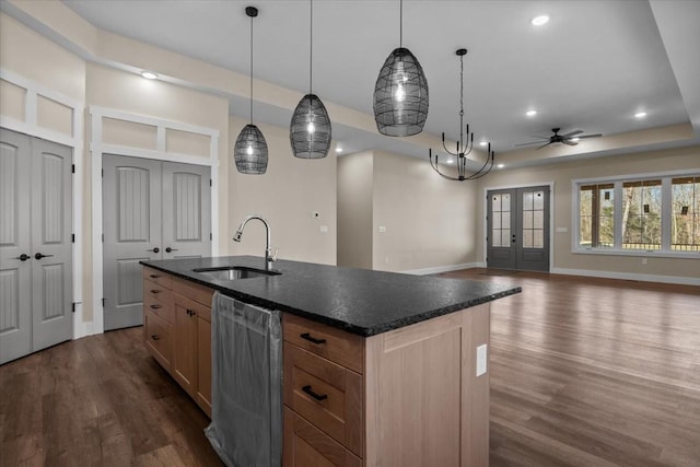 kitchen featuring dark wood-style floors, a center island with sink, recessed lighting, stainless steel dishwasher, and a sink