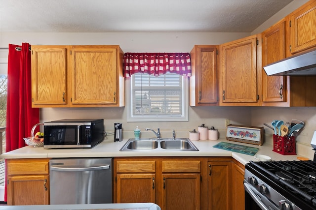 kitchen featuring a textured ceiling, stainless steel appliances, and sink