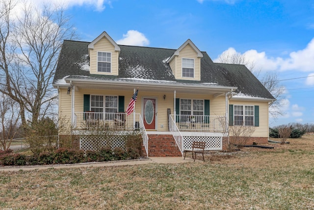 new england style home with covered porch and a front lawn