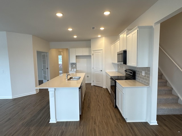 kitchen with sink, a center island with sink, dark hardwood / wood-style floors, stainless steel appliances, and white cabinets