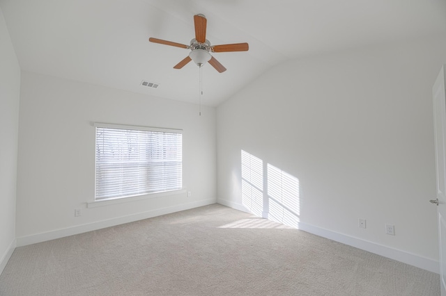 carpeted spare room with ceiling fan and vaulted ceiling