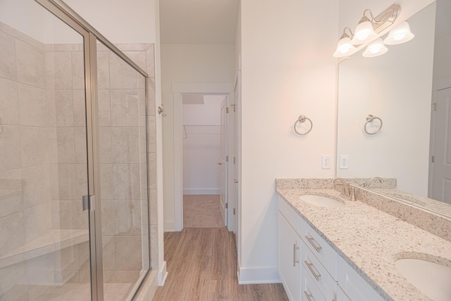 bathroom featuring wood-type flooring, vanity, and an enclosed shower