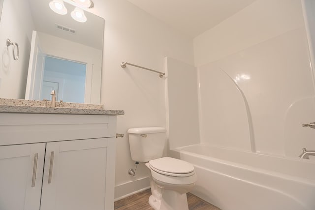 full bathroom featuring hardwood / wood-style flooring, vanity, toilet, and shower / tub combination