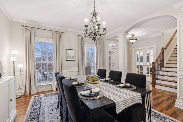 dining room featuring ornamental molding, wood-type flooring, plenty of natural light, and an inviting chandelier