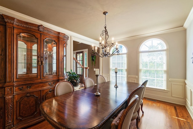 dining area featuring hardwood / wood-style flooring, a notable chandelier, and ornamental molding