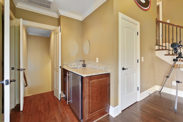 interior space with refrigerator, sink, crown molding, dark hardwood / wood-style floors, and light stone countertops